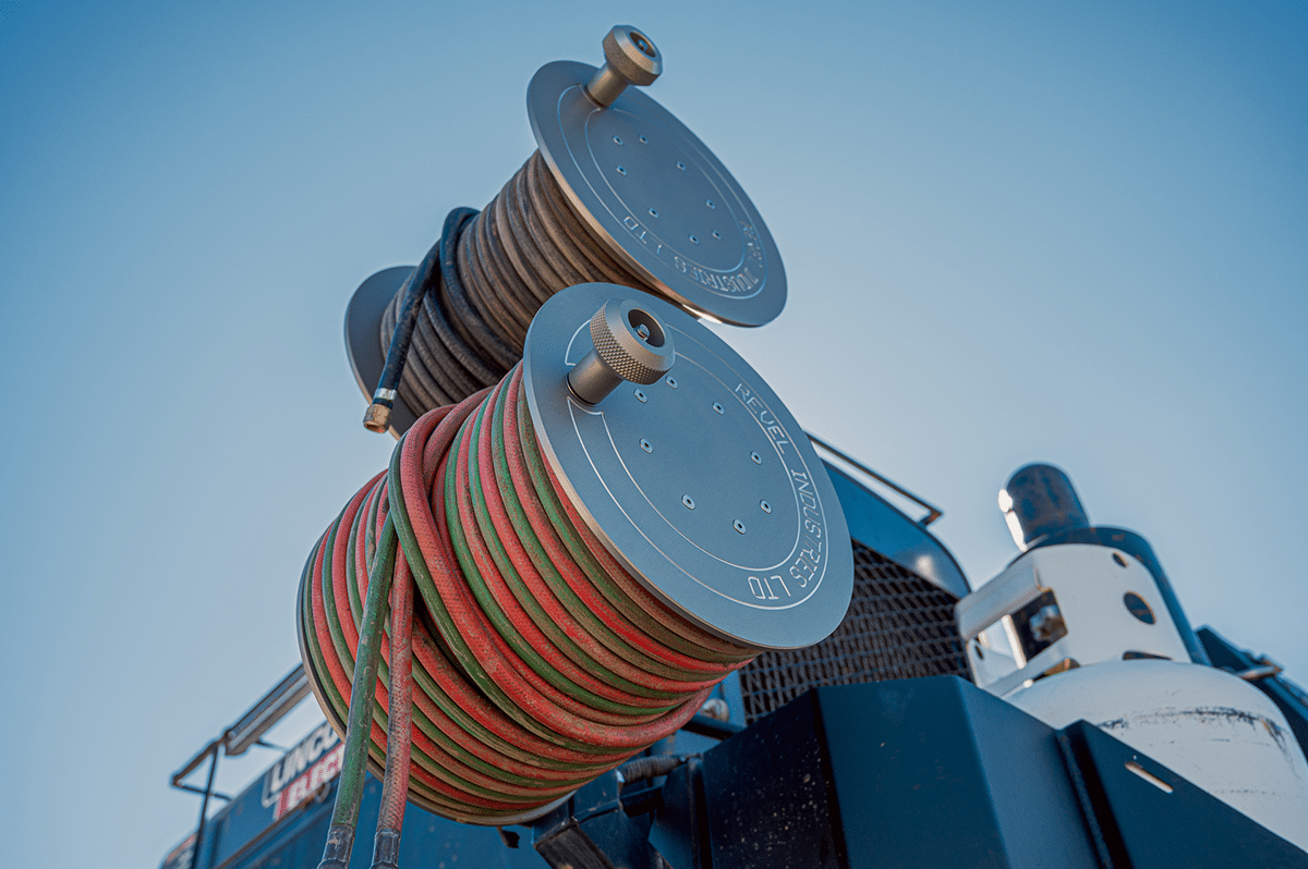 A coiled red and green hose neatly arranged on reels, showcasing its vibrant colors and practical design