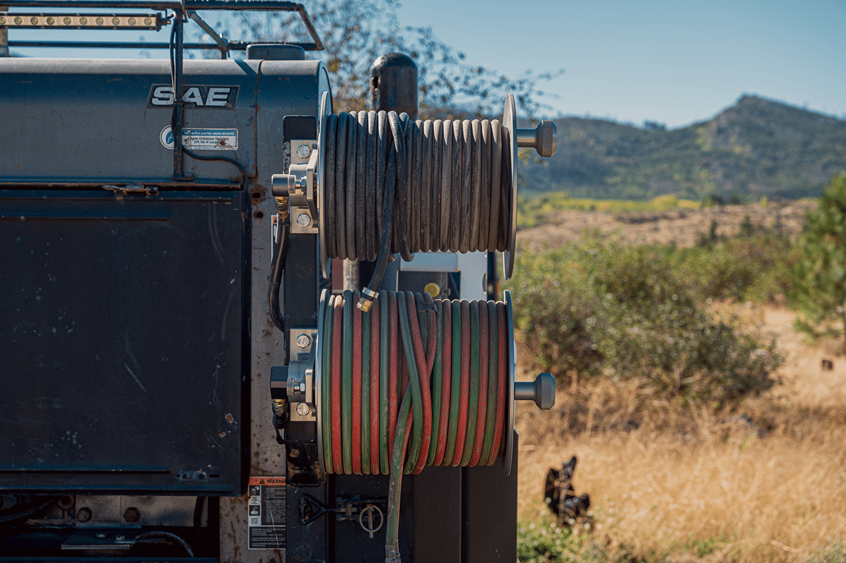 A truck equipped with a hose and carrying reels, ready for operational use in various applications