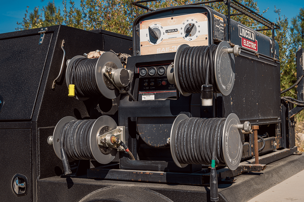 A close-up of a large Revel Industries machine with an attached hose, highlighting its industrial design and functionality
