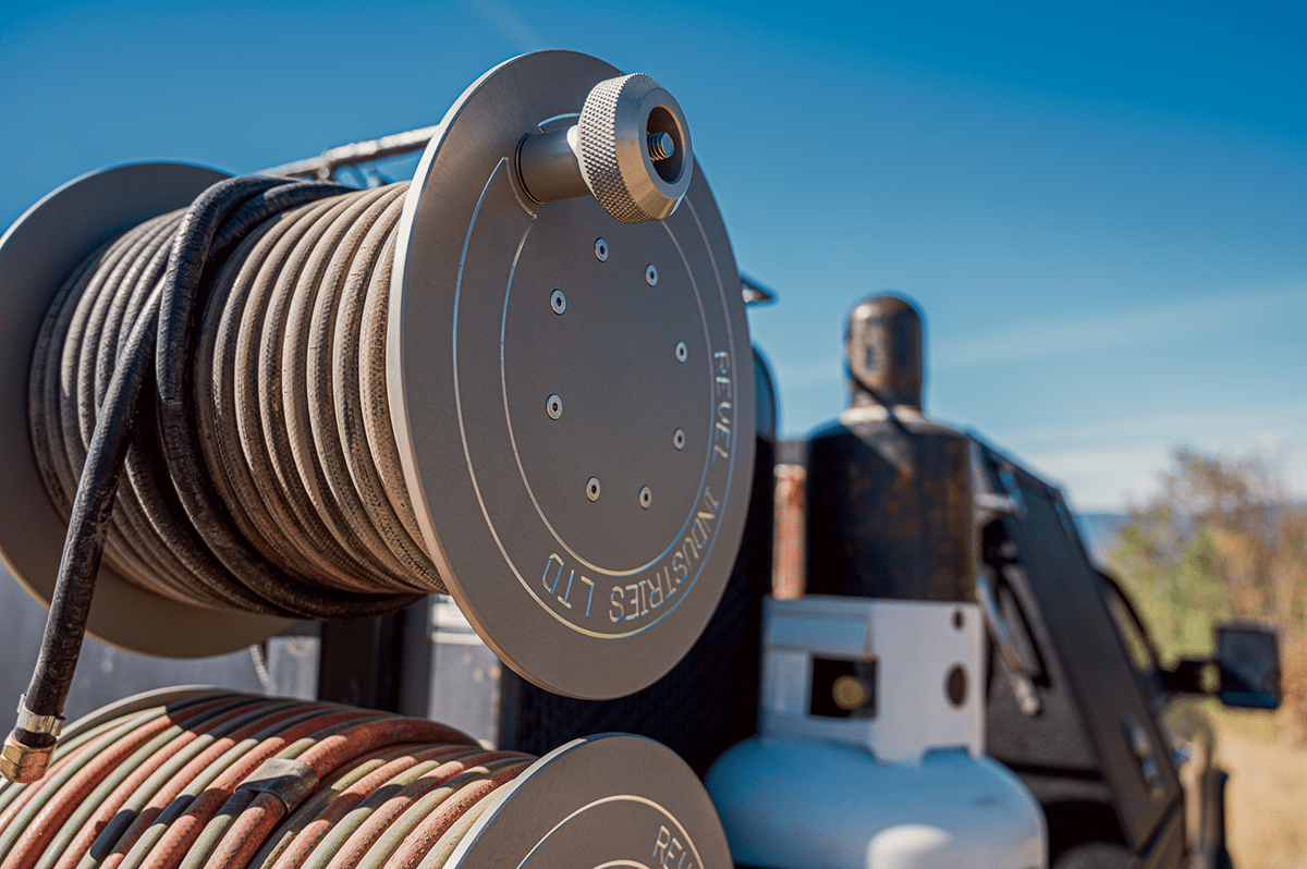 A Revel Industries hose reel mounted on a truck, featuring a hose securely attached for efficient use