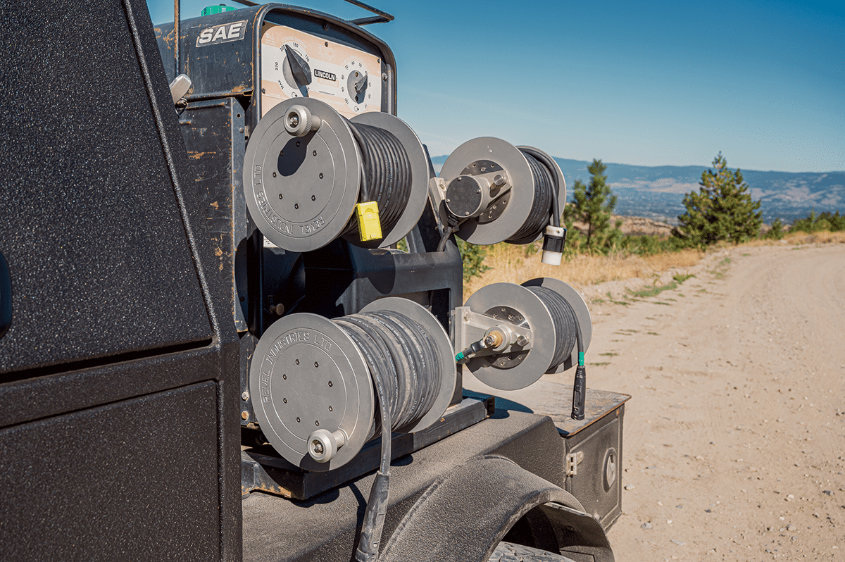 A truck loaded with numerous spools of wire, ready for transport to its next destination
