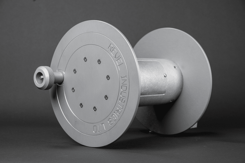 A gray air reel with a metal handle displayed against a black background