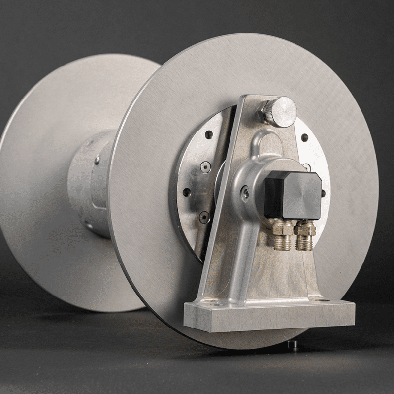 Stainless steel reel with a metal shaft and cover, manufactured by Revel Industries Ltd.