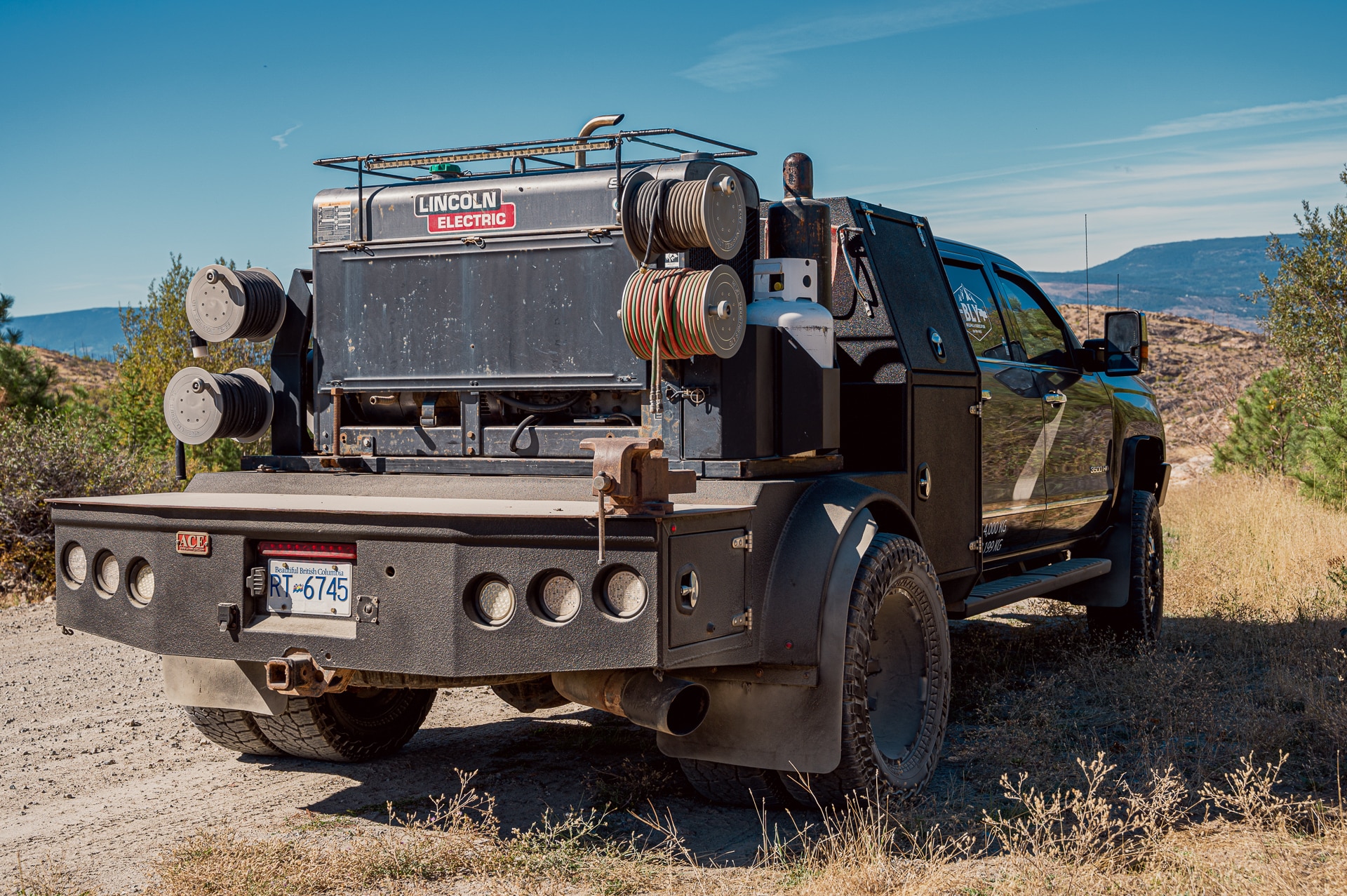 A truck with a large back end carrying Welding Reels drives along a rugged dirt road
